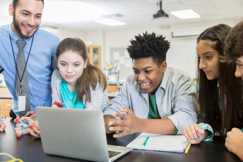 High school science teacher shows laptop video to students